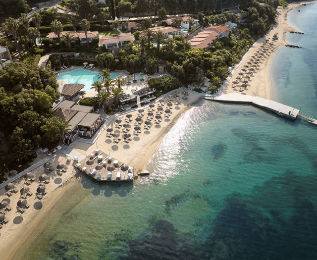 Eagles Resort Chalkidiki sandy beach with trees and umbrellas, and swimming pool